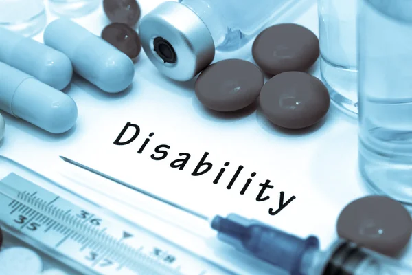 Інвалідність - діагноз, написаний на білому аркуші паперу. Шприц і вакцина проти наркотиків . — стокове фото