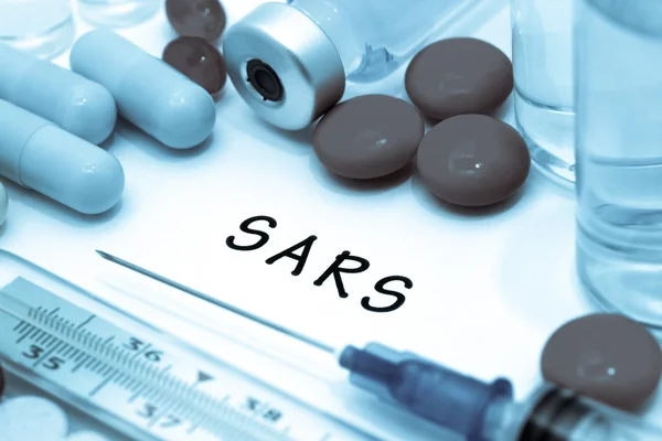 SARS - diagnóstico escrito em um pedaço de papel branco. Seringa e vacina com medicamentos . — Fotografia de Stock