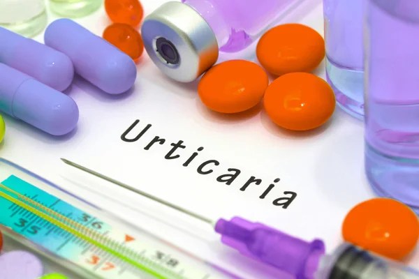 Urticaria - diagnóstico escrito en un papel blanco. Jeringa y vacuna con medicamentos . — Foto de Stock