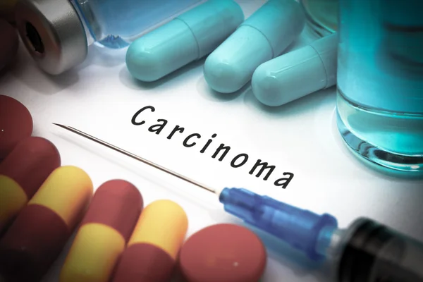 Carcinoma: diagnóstico escrito en un papel blanco. Jeringa y vacuna con medicamentos — Foto de Stock