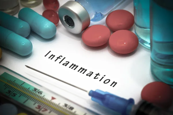 Inflamación - diagnóstico escrito en un papel blanco. Jeringa y vacuna con medicamentos . — Foto de Stock