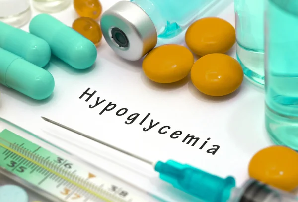 Hypoglykemi - diagnos skriven på ett vitt papper. Sprutan och vaccin med droger — Stockfoto