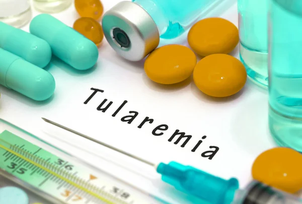 Tularemia- diagnóstico escrito en un pedazo de papel blanco. Jeringa y vacuna con medicamentos . — Foto de Stock