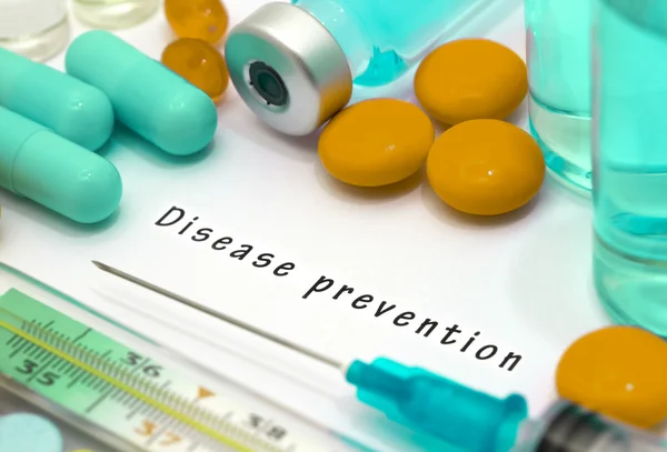 Prevención de enfermedades - diagnóstico escrito en un papel blanco. Jeringa y vacuna con medicamentos . — Foto de Stock