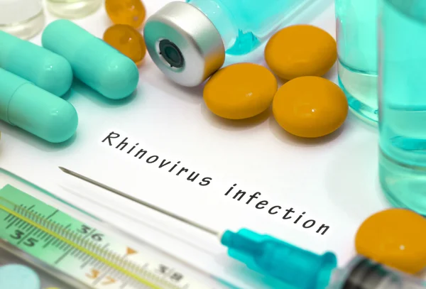 Infecção por rinovírus - diagnóstico escrito em um pedaço de papel branco. Seringa e vacina com medicamentos . — Fotografia de Stock