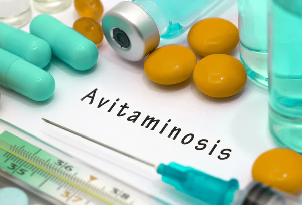Avitaminosis - diagnóstico escrito en un papel blanco. Jeringa y vacuna con medicamentos . — Foto de Stock