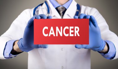 Doktorun mavi eldiven gösterilerinde kelime kanser eller. Eldiven gri arka plan üzerinde doktor. Tıp kavramı.
