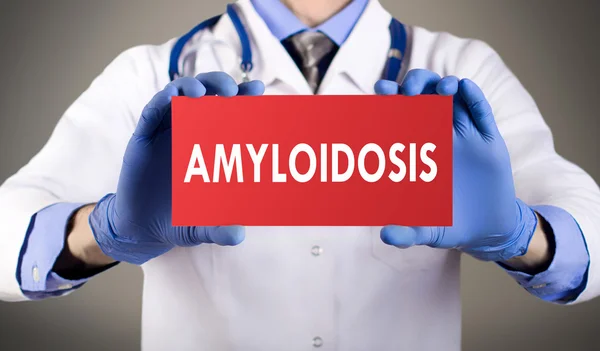 As mãos do médico de luvas azuis mostram a palavra amiloidose. Doutor em luvas no fundo cinzento. Conceito médico . — Fotografia de Stock