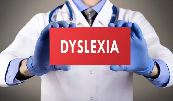 Doctor's handen in handschoenen blauw toont het woord dyslexie. Medische concept. — Stockfoto