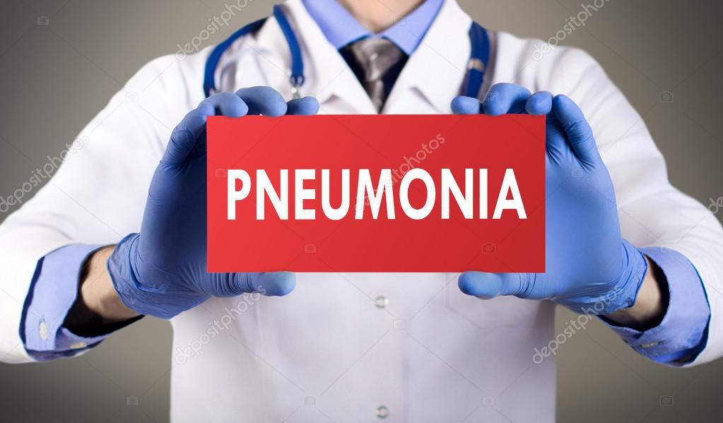 Doctor's hands in blue gloves shows the word pneumonia. Medical concept.