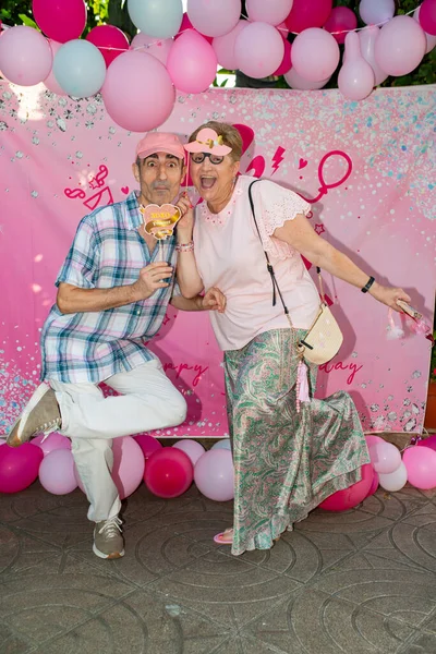 Neşeli bir Barbie partisinde neşeli bir poz veren olgun bir çift, neşeli atmosferin tadını çıkarıyor ve neşeyle kutluyorlar.