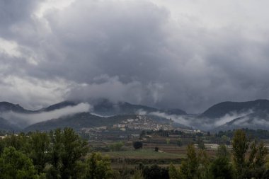 Penyarroya de Tastavins köyü bulutlu bir kış günü Matarranya dağlarında yuva yapmış, sis zirveleri kaplamış.