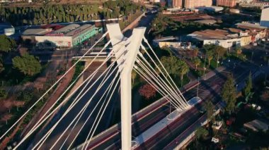 Bu video, bir nehrin üzerinde, kentsel yaşamı ve modern mühendisliği ön plana çıkaran dikkate değer bir köprüyü gösteren çarpıcı bir şehrin hava görüntülerini içeriyor.