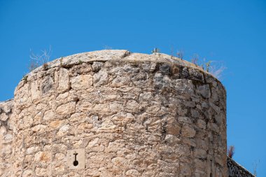 Eski taş kule berrak mavi gökyüzüne karşı kırsal doku ve mimari detay ile.
