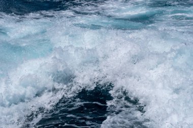 Dinamik okyanus dalgaları köpüklü su ve derin mavi deniz ile çarpışıyor..