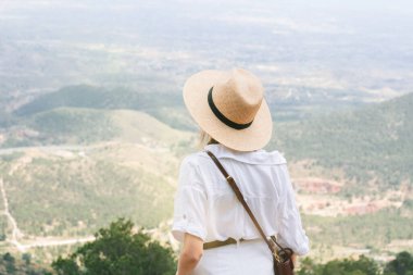 Açık havada manzaralı dağ manzarasından hoşlanan şapkalı bir kadın..