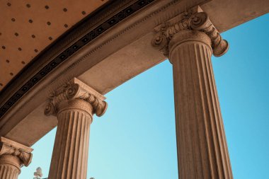 Mimari zarafet: berrak mavi gökyüzü altındaki klasik sütunlar.