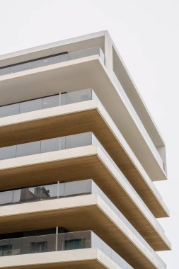 Modern mimari cam ve ahşap aksanlı gösterişli apartman balkon tasarımını ön plana çıkarıyor.