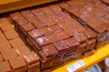 Bir gurme dükkanında sergilenen kurutulmuş çiçeklerle birlikte sanatsal çikolata kareleri..