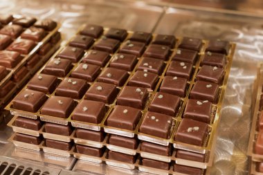 Pastane vitrininde sergilenen gurme çikolata kareleri.