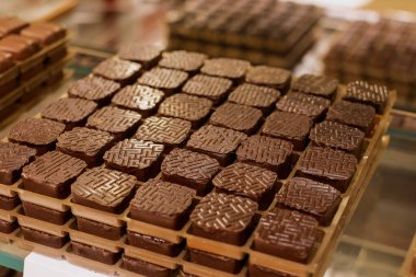 Bir şekerleme dükkanında karmaşık desenleri olan sanatkar çikolata karelerinin zarif bir gösterisi..