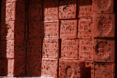 Sıcak ışıklandırmada kabartmalı metin ve organik dokuya sahip doğal sabun çubukları istiflenmiş.