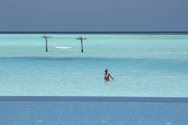 Hammock in water in  Maldives and infinity pool  clipart