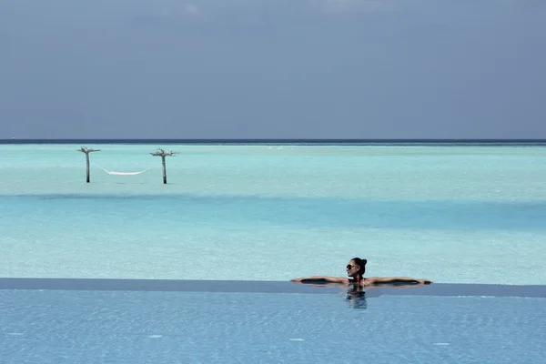 Menina na piscina infinita em Maldivas — Fotografia de Stock