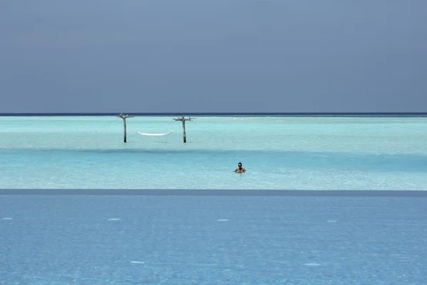 Hamac dans l'eau et fille aux Maldives et piscine à débordement — Photo
