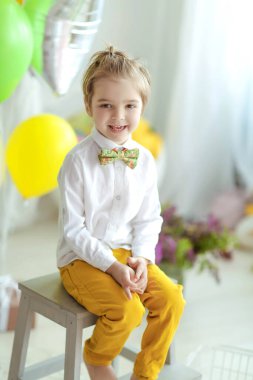 Sarışın bir çocuk oyun odasında oynar ve eğlenir..