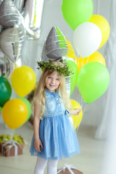 Uma menina contra um fundo de balões de gel coloridos. — Fotografia de Stock