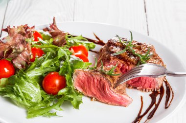 biftek ve bir pansteak kiraz domates ve domates bir tavada