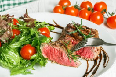 biftek ve bir pansteak kiraz domates ve domates bir tavada