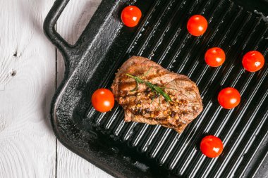 biftek tavada holding forseps ve kiraz domates