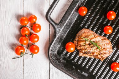 Forseps ve kiraz domates forseps ve kiraz domates bir tavada tutan bir pansteak holding biftek