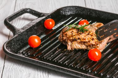 biftek tavada holding forseps ve kiraz domates