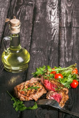 biftek ve ahşap bir masa salataya