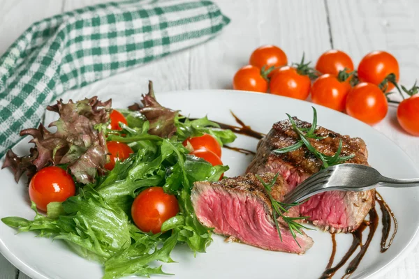 Bife e tomate cereja em um pansteak e tomate cereja em uma panela — Fotografia de Stock