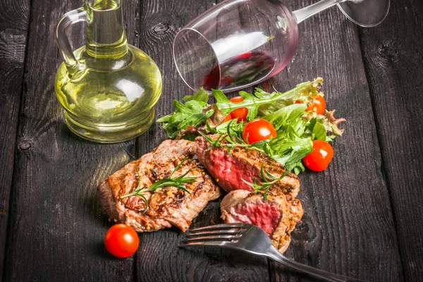 biftek ve ahşap bir masa salataya