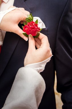 Gelin Damat siyah elbiseli üzerinde çiçek yaka çiçeği koyarak