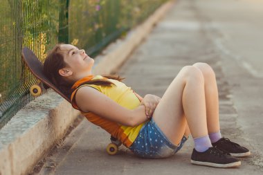 Moda çocuk kavramı - yaz aylarında kaykay olan bir tişört giyen şık küçük kız çocuk