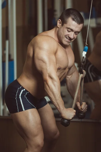 Muskularny mężczyzna ćwiczeń w siłowni. — Zdjęcie stockowe
