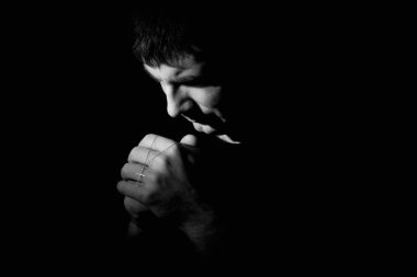 Adam Tanrı'ya dua aşağı diz çökmüş