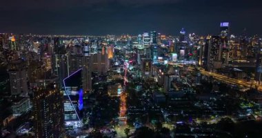 Bangkok, Tayland 'ın parlayan gökdelenleri, renkli şehir ışıkları, yoğun trafik ve hareketli bir şehir silüeti olan gece uçuşu. Güneydoğu Asya başkentinde dinamik kentsel yaşam.
