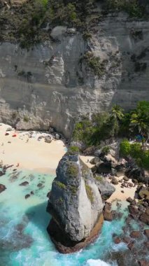 Kireçtaşı kayalıkları, turkuvaz okyanusu ve Endonezya, Bali 'deki Nusa Penida Adası' ndaki beyaz kumların ikonik elmas sahili..