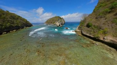 Atuh Sahili ve Endonezya 'daki Nusa Penida Adası' ndaki turkuaz okyanus suları üzerinde uçan FPV insansız hava aracı.