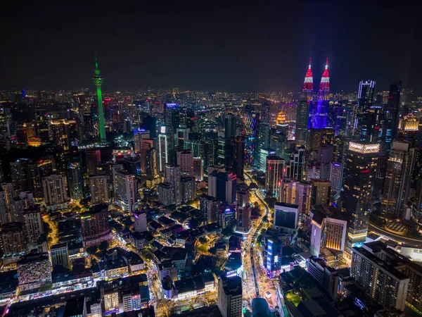 Kuala Lumpur 'un parlayan gökdelenleri, trafik ve gece ikonik kuleleri olan hava aracı görüntüsü. Malezya 'daki modern şehir ışıkları ve şehir manzarası.