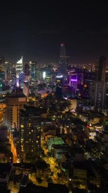 Ho Chi Minh City 'nin gökdelenleri, parlak ışıkları ve hareketli trafiği olan gece uçuşları. Vietnam 'ın başkentinde modern şehir manzarası ve dinamik gece hayatı.