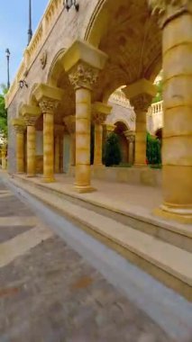 Phu Quoc Adası, Vietnam 'da Sunset Town' da zarif mimaride yürüyen bir kadının sinematik FPV görüntüsü. Lüks tatil beldesi atmosferi, tropikal seyahat beldesi ve modern Asya yaşam tarzı.