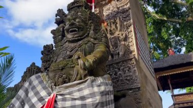 Endonezya, Bali 'deki Hindu tapınağı girişinde geleneksel Balili taş koruyucu heykeller. Sembolik oymalar ve şemsiyeli kutsal mimari. Emanet, kültür ve seyahat kavramları.
